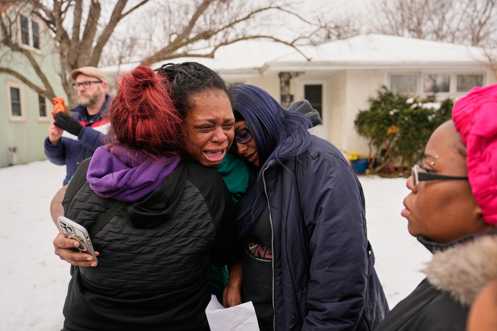 ADDS IDENTIFICATION: Teyana Gibson Brown, center, wife of Garrison Gibson, reacts after federal immigration officers arrested Garrison Gibson, Sunday, Jan. 11, 2026, in Minneapolis. (AP Photo/John Locher)