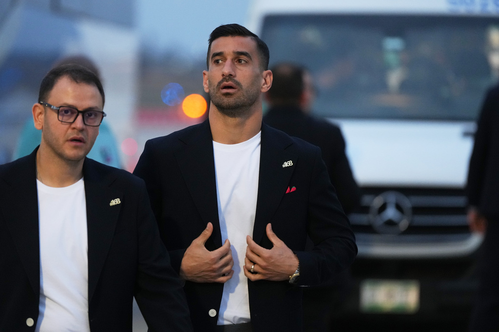 Iran's Ehsan Hajisafi, center, walks with a team official as he arrives with his teammates for the World Cup soccer tournament in Tijuana, Mexico, Sunday, June 7, 2026. (AP Photo/Gregory Bull)