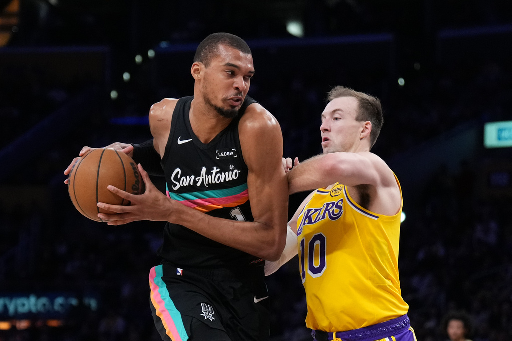San Antonio Spurs forward Victor Wembanyama (1) is defended by Los Angeles Lakers guard Luke Kennard (10) during the first half of an NBA basketball game Tuesday, Feb. 10, 2026, in Los Angeles. (AP Photo/Jae C. Hong)