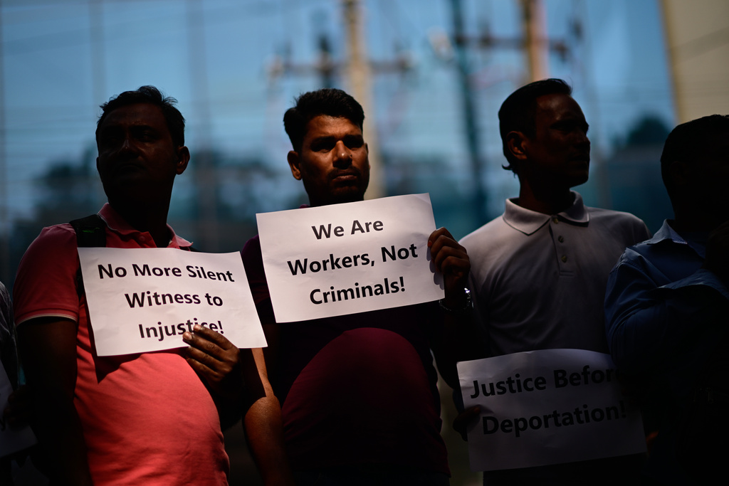 Bangladeshi workers who were employed by Malaysian companies hold banners during a protest in front of the Ministry of Expatriates' Welfare and Overseas Employment demanding unpaid wages, fair compensation and an end to alleged abuse by Malaysian employers, in Dhaka, Bangladesh, Monday, Nov. 10, 2025. (AP Photo/Mahmud Hossain Opu)