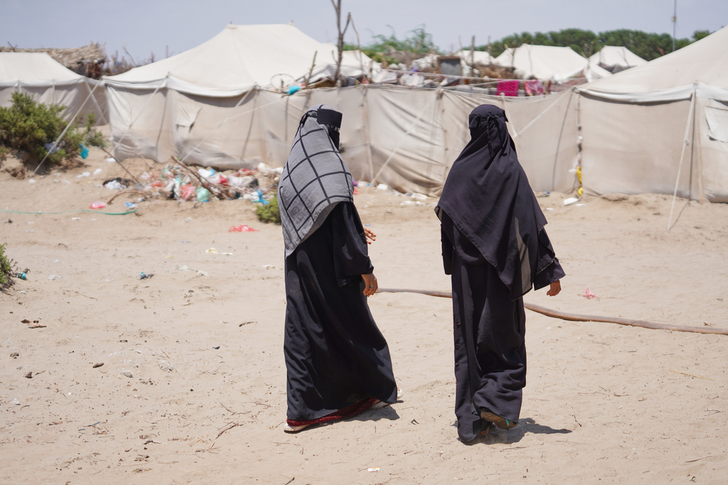 Displaced Yemenis, from Al Khawkhah city, 400 kilometers (249 miles) south west of Sanaa, walk past their temporary shelter in Aden, Yemen, Sunday, Sept. 13, 2026. (AP Photo/Abdulnasser Alseddik)