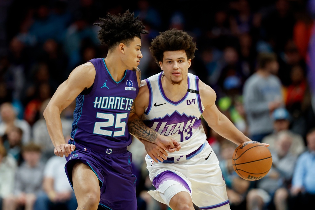 Utah Jazz guard Walter Clayton Jr. (13) brings the ball upcourt against Charlotte Hornets guard KJ Simpson during the first half of an NBA basketball game in Charlotte, N.C., Sunday, Nov. 2, 2025. (AP Photo/Nell Redmond)