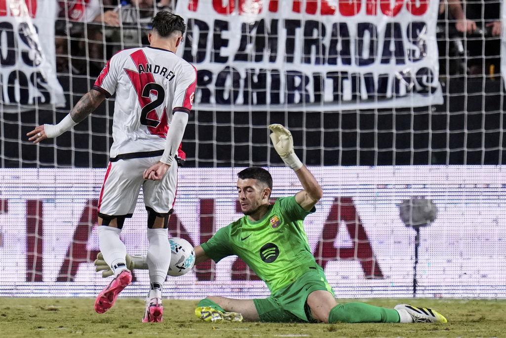 Barcelona's goalkeeper Joan García makes a save from Rayo's Andrei Ratiu during the Spanish La Liga soccer match between Rayo Vallecano and FC Barcelona at the Vallecas stadium in Madrid, Spain, Sunday, Aug. 31, 2025. (AP Photo/Manu Fernandez)