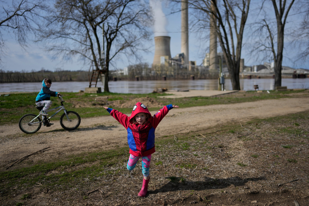 John White Jr.'s children, Paisley, 3, right, and Malachi, 5, play outside their home at the Lock 24 RV Park and Campground in Racine, Ohio, Saturday, March 14, 2026, across the Ohio River from the coal-fired Mountaineer Power Plant, near New Haven, W.Va. (AP Photo/Carolyn Kaster)