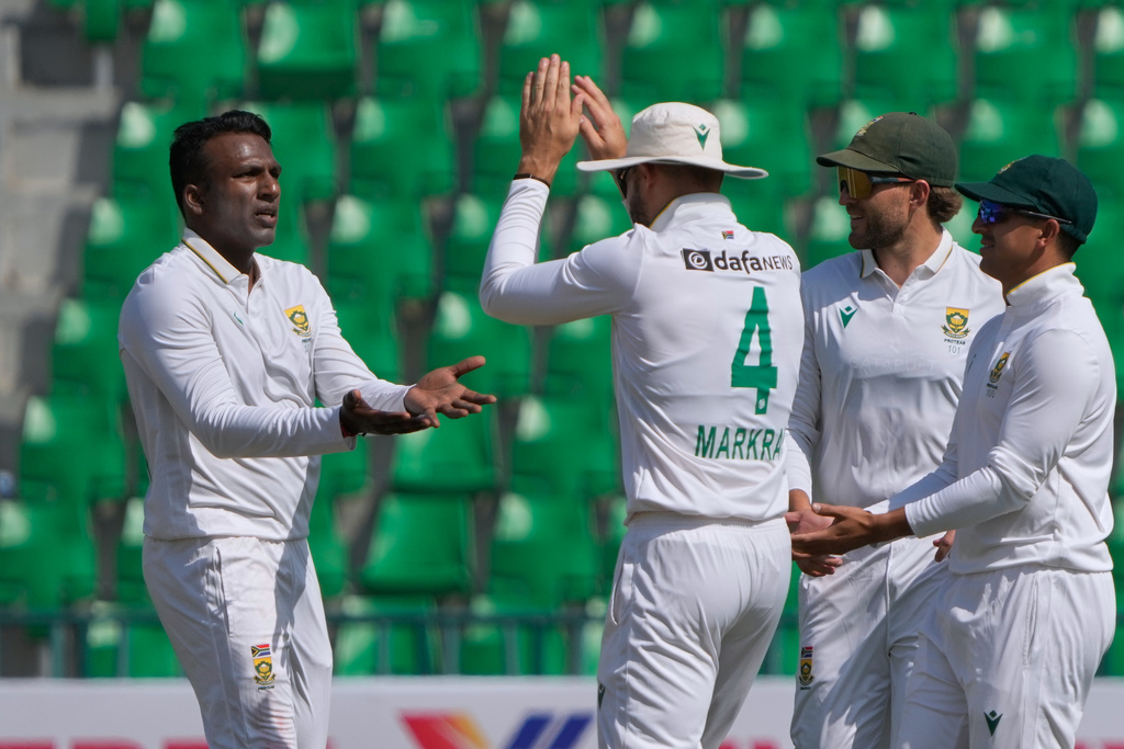 South Africa's Senuran Muthusamy, left, celebrates with teammates after taking the wicket of Pakistan's Mohammad Rizwan during the second day of the first test cricket match between Pakistan and South Africa, in Lahore, Pakistan, Monday, Oct. 13, 2025. (AP Photo/K.M. Chaudary)