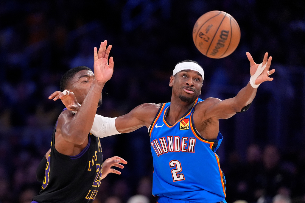 Oklahoma City Thunder guard Shai Gilgeous-Alexander, right, takes a pass while under pressure from Los Angeles Lakers forward Rui Hachimura during the first half of Game 4 in a second-round NBA basketball playoffs series Monday, May 11, 2026, in Los Angeles. (AP Photo/Mark J. Terrill)