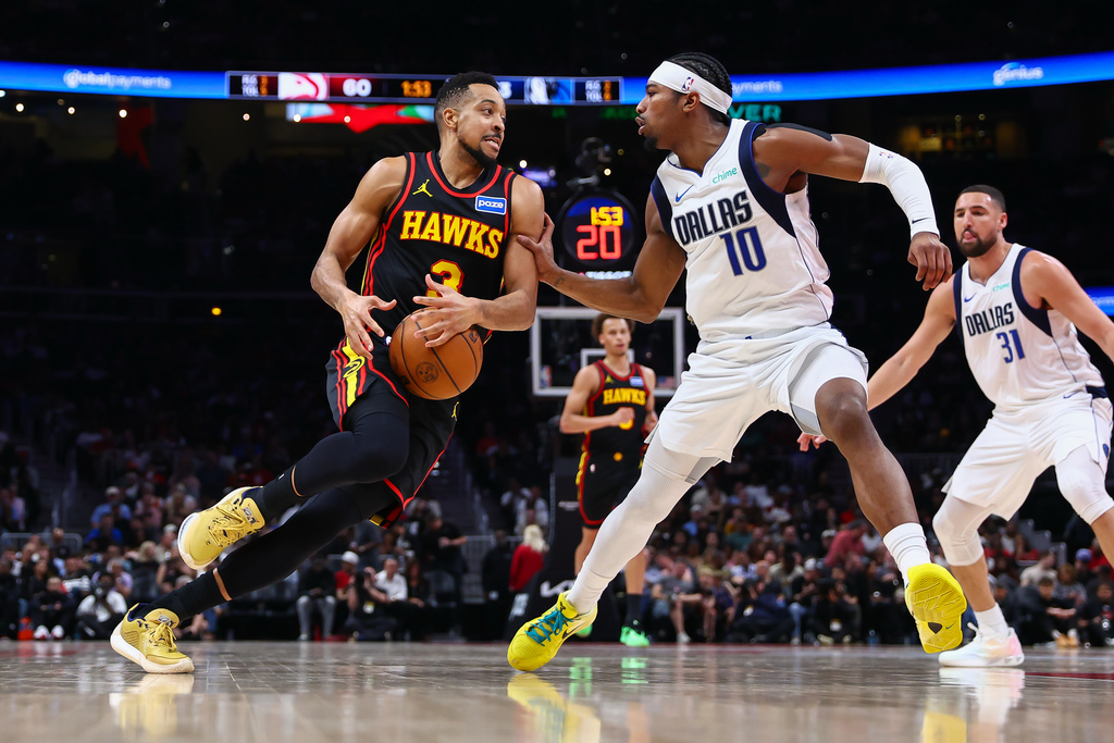 Atlanta Hawks guard CJ McCollum, left, drives to the basket against Dallas Mavericks guard Brandon Williams (10) during the first half of an NBA basketball game, Tuesday, March 10, 2026, in Atlanta. (AP Photo/Colin Hubbard)
