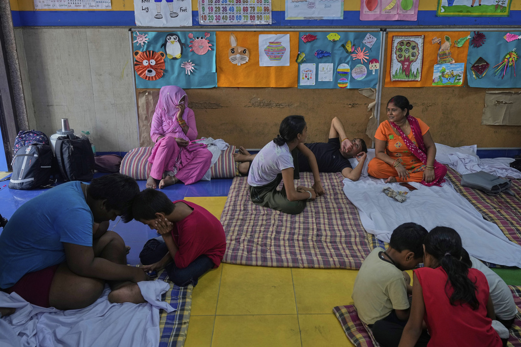Bindu Pandey, right, talks to her relatives in a temporary school shelter, which houses residents displaced from the banks of the Yamuna River by incessant rain in the higher regions, in New Delhi, India, Friday, Sept. 5, 2025. (AP Photo/Manish Swarup)