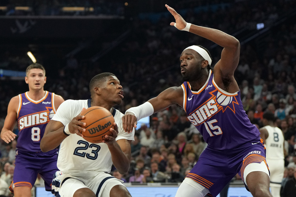 Memphis Grizzlies forward Cedric Coward drives on Phoenix Suns center Mark Williams (15) during the first half of an NBA basketball game, Wednesday, Oct. 29, 2025, in Phoenix. (AP Photo/Rick Scuteri)