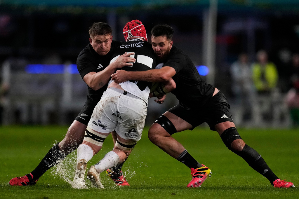 All Blacks' Ethan de Groot, left, with his teammate Josh Lord, right, tackle Sharks' Hendrè Stassen, during a friendly rugby match between Sharks and All Blacks, in Durban, Tuesday, Aug. 11, 2026. (AP Photo/Themba Hadebe)