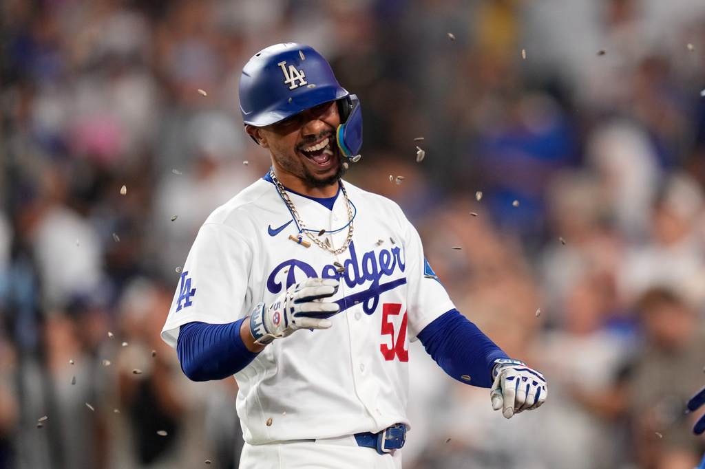 Los Angeles Dodgers' Mookie Betts has seeds thrown at him after hitting a two-run home run during the third inning of a baseball game against the Cincinnati Reds, Wednesday, Sept. 9, 2026, in Los Angeles. (AP Photo/Mark J. Terrill)