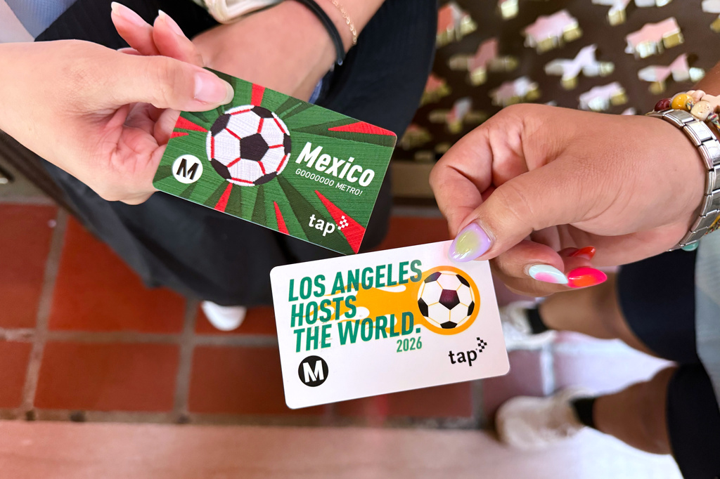 Michelle Valladares, left, and Yasmin Cortez show their FIFA World Cup themed Metro tap cards before attending a watch party on Friday, June 26, 2026, in Los Angeles. (AP Photo/Jaimie Ding)