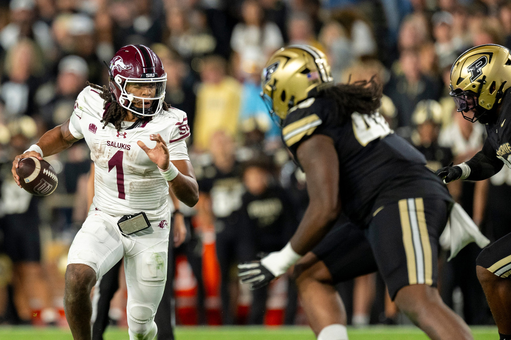 FILE - Southern Illinois quarterback DJ Williams (1) runs the ball into the Purdue defense during an NCAA football game on Sept. 6, 2025, in West Lafayette, Ind. (AP Photo/Doug McSchooler, File)