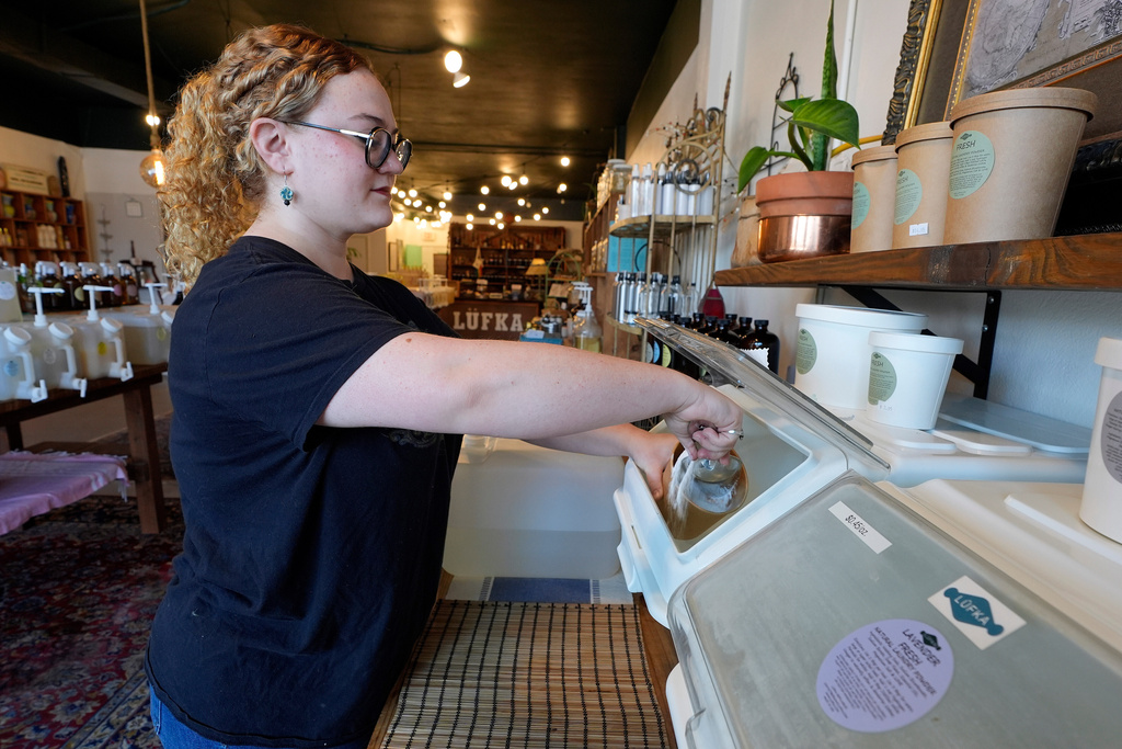 Aaralyn Holt refills laundry detergent containers at Lufka Refillable Zero Waste store Wednesday, Feb. 18, 2026, in Tampa, Fla. (AP Photo/Chris O'Meara)