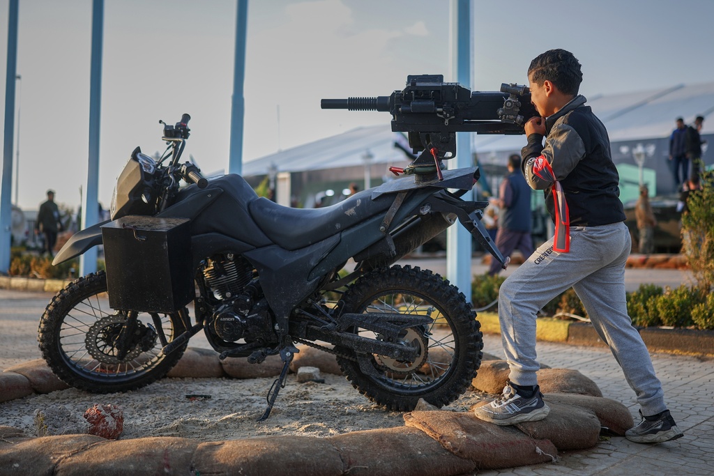 A boy handles a weapon at the "Syrian Revolution Military Exhibition," which opened last week ahead of the first anniversary of the ousting of the Bashar Assad regime in Damascus, Syria, Sunday, Dec. 7, 2025. (AP Photo/Ghaith Alsayed)
