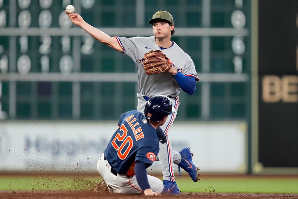 Texas Rangers second baseman Justin Foscue, top, completes a double play over Houston Astros' Nick Allen (20) during the third inning of a baseball game, Sunday, May 17, 2026, in Houston. (AP Photo/Eric Christian Smith)