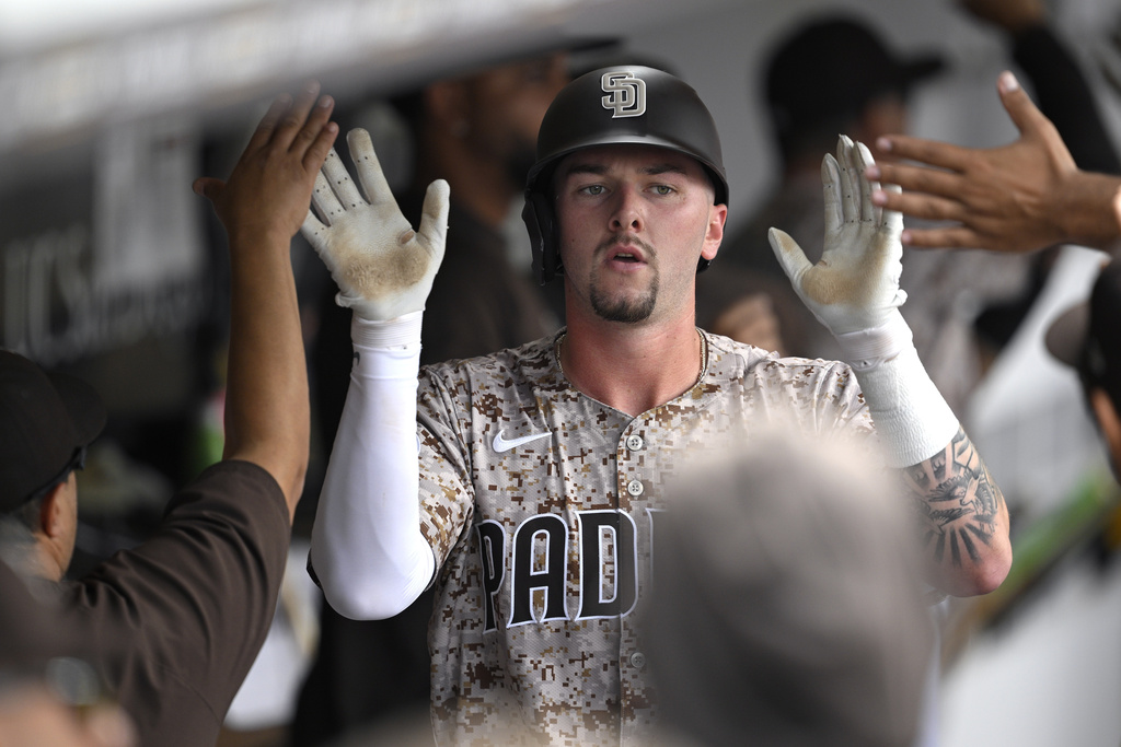 San Diego Padres' Jackson Merrill is congratulated in the dugout after hitting a three-run home run against the Colorado Rockies during the second inning of a baseball game Sunday, Sept. 14, 2025, in San Diego. (AP Photo/Orlando Ramirez)