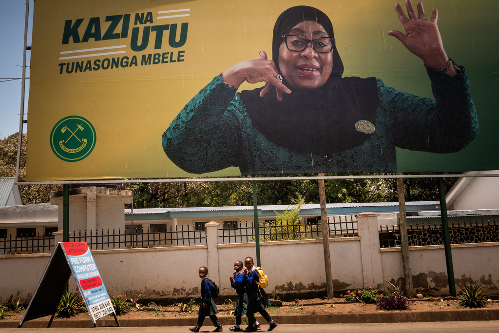 School children walk past a billboard for Tanzanian presidential candidate Samia Suluhu Hassan, of the ruling Chama Cha Mapinduzi party, in Arusha, Tanzania, Oct. 8, 2025. (AP Photo)