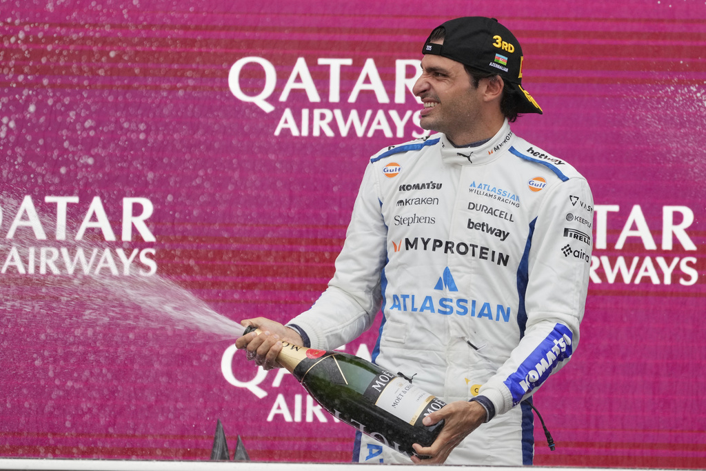Third-placed Williams driver Carlos Sainz of Spain stands on the podium after the Azerbaijan Formula One Grand Prix in Baku, Azerbaijan, Sunday, Sept. 21, 2025. (AP Photo/Darko Bandic)