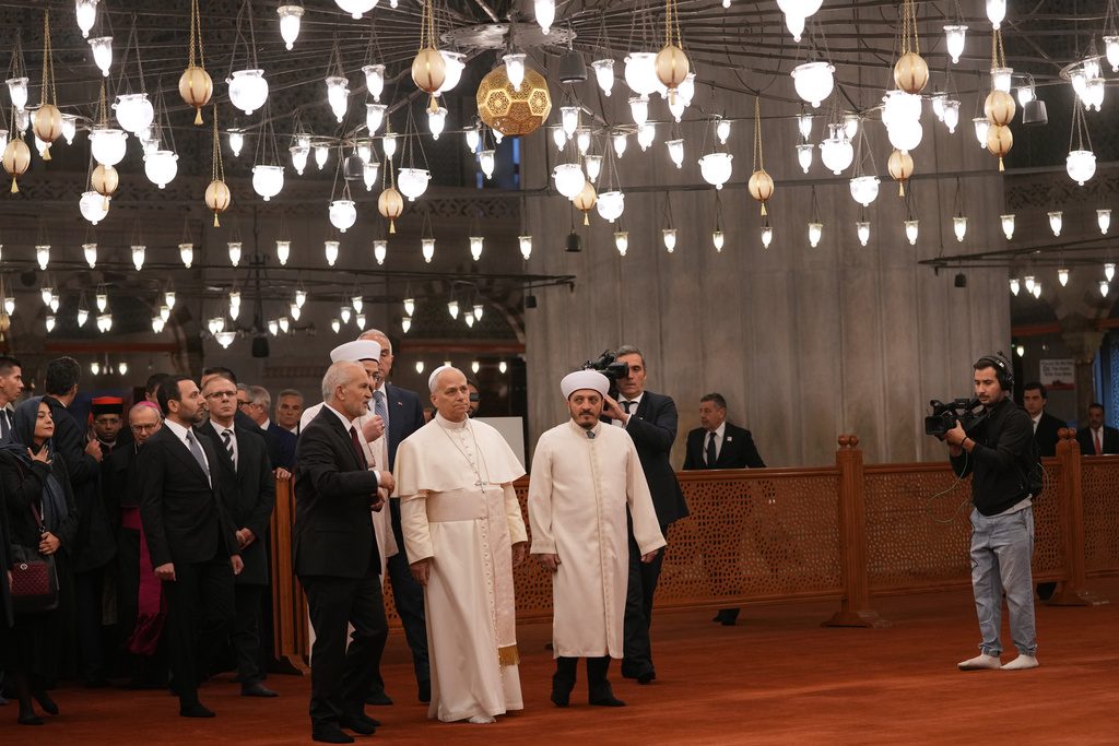 Pope Leo XIV, center, walking with Muezzin Musa Asgın Tunca, left, Dr. Emrullah Tuncel, second from left, and Imam of Mosque Sultanahmet Fatih Kaya, visits the Sultan Ahmed Mosque in Istanbul, Saturday, Nov. 29, 2025. (AP Photo/Domenico Stinellis)