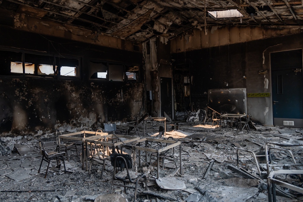Burned desks sit inside a school after wildfires swept through Punta de Parra, Chile, Monday, Jan. 19, 2026. (AP Photo/Javier Torres)