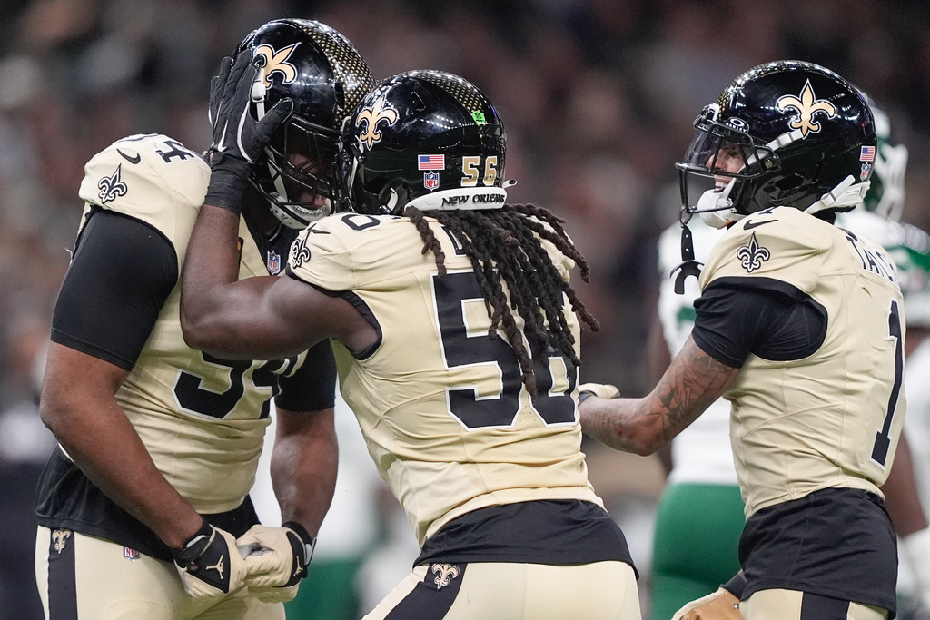 From left, New Orleans Saints defensive end Cameron Jordan, outside linebacker Demario Davis and cornerback Alontae Taylor (1) celebrate after a sack during the first half of an NFL football game against the New York Jets, Sunday, Dec. 21, 2025, in New Orleans. (AP Photo/Gerald Herbert)