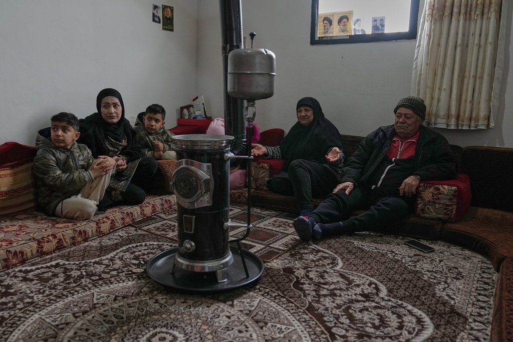 Ihasn Midlij, 70, centre, who fled from Syria with her husband Shayban, 73, right, sits with their family on their housing unit at the Imam Ali Housing Compound, where hundreds of mostly Lebanese and Syrian Shiite Muslims displaced from Syria reside, in Hermel, northeast Lebanon, Jan. 30, 2026. 2026. (AP Photo/Hussein Malla)