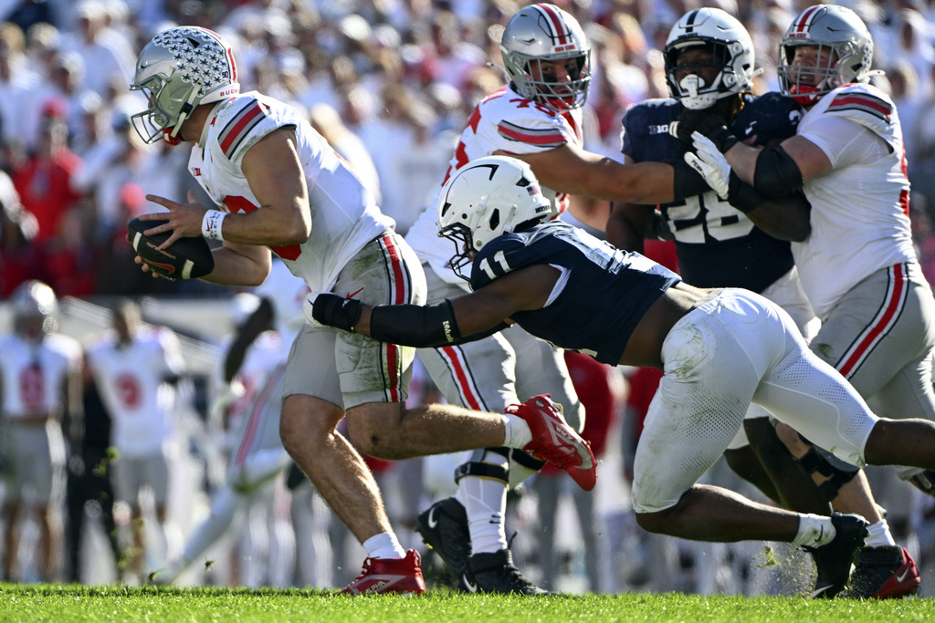 FILE - Penn State defensive end Abdul Carter (11) tackles Ohio State quarterback Will Howard (18) during the second half of an NCAA college football game against Ohio State, Nov. 2, 2024, in State College, Pa. (AP Photo/Barry Reeger, File)