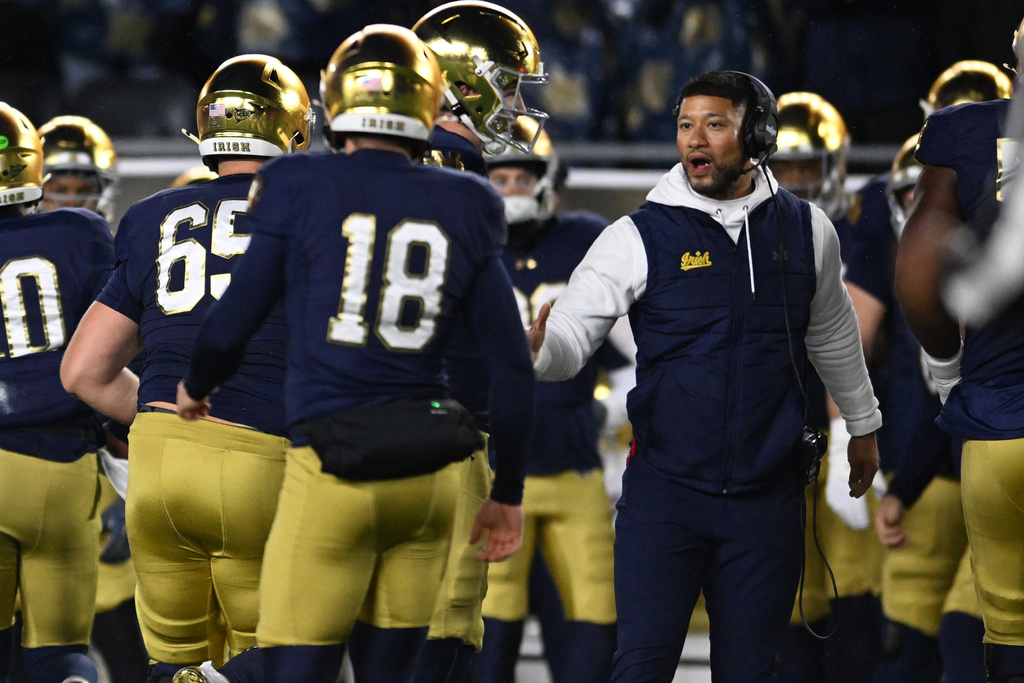 Notre Dame head coach Marcus Freeman, right, celebrates with kicker Erik Schmidt (18) on the sideline after a point after field goal during the first quarter of an NCAA football game against Navy, Saturday, Nov. 8, 2025, in South Bend, Ind. (AP Photo/Paul Beaty)