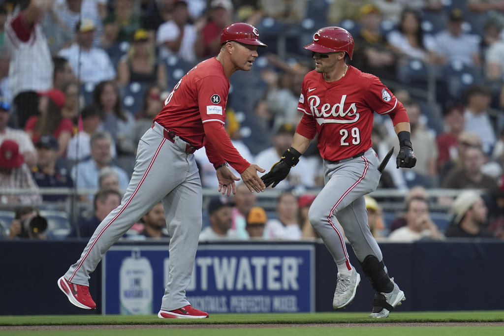 Cincinnati Reds' TJ Friedl, right, celebrates with third base coach J.R. House after hitting a home run during the first inning of a baseball game against the San Diego Padres Monday, Sept. 8, 2025, in San Diego. (AP Photo/Gregory Bull)