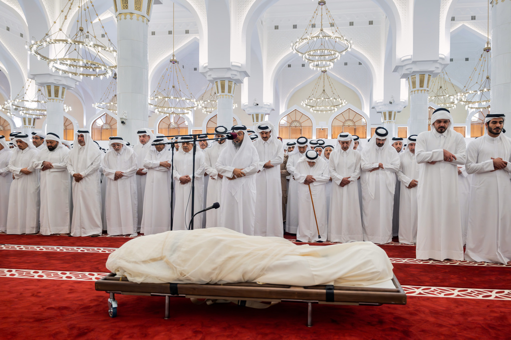 In this picture released by the Qatar Amiri Diwan media office, mourners pray over the body of Qatar's former ruler, Sheikh Hamad bin Khalifa Al Thani, at the Mohammed bin Abdulwahab Mosque in Doha, Qatar, Sunday, July 12, 2026. (Qatar Amiri Diwan via AP)