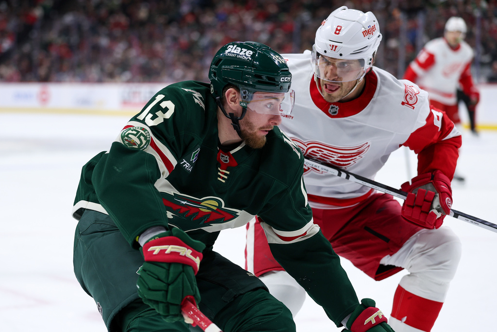 Minnesota Wild center Yakov Trenin, left, skates with the puck as Detroit Red Wings defenseman Ben Chiarot (8) defends during the third period of an NHL hockey game Thursday, Jan. 22, 2026, in St. Paul, Minn. (AP Photo/Matt Krohn)
