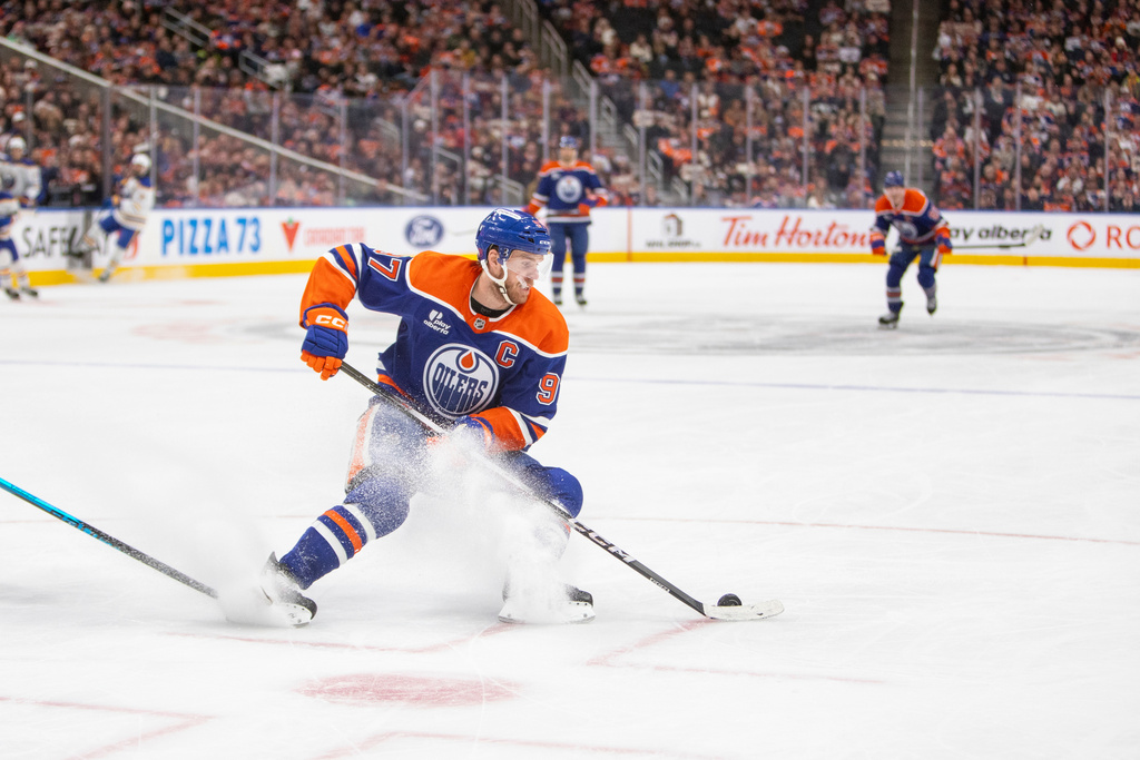 Edmonton Oilers Connor McDavid moves the puck during the second period of an NHL hockey game in Edmonton, Alberta, Tuesday, Dec. 9, 2025. (Amber Bracken/The Canadian Press via AP)