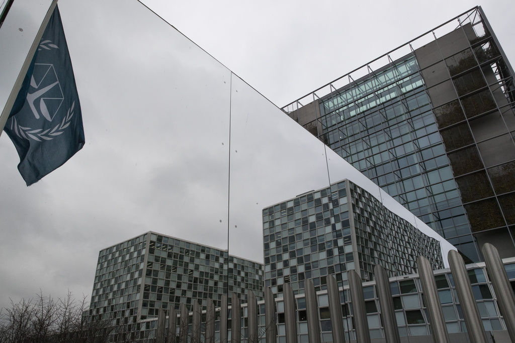 FILE - The flag of the International Criminal Court is reflected in a mirrored wall of the building in The Hague, Netherlands, Jan. 16, 2019. (AP Photo/Peter Dejong, file)