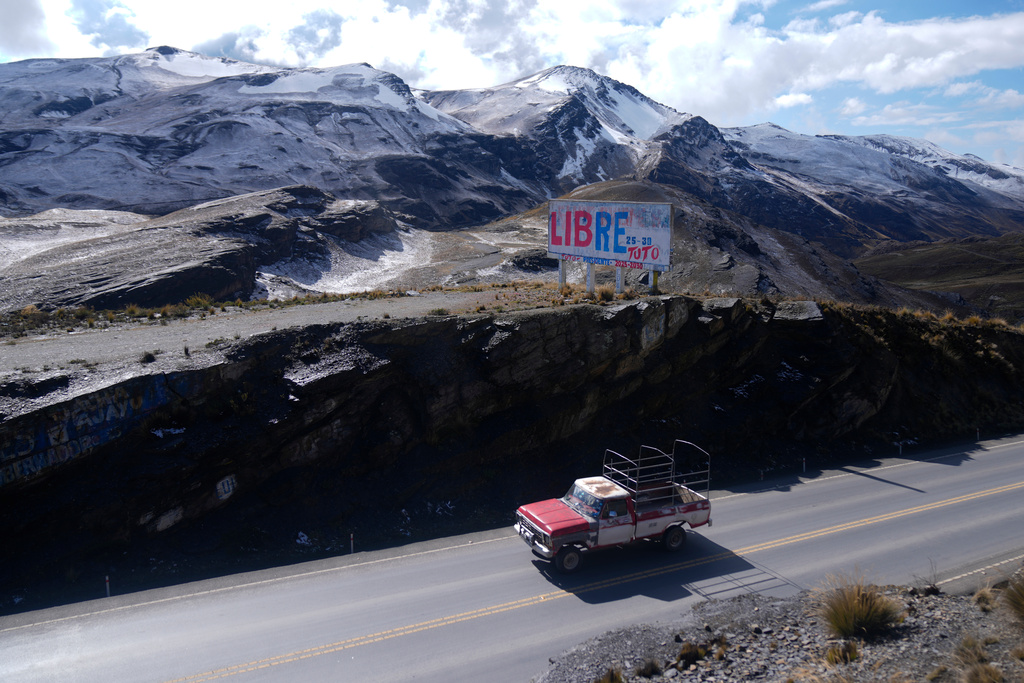 A car drives past a banner promoting presidential candidate Jorge "Tuto" Quiroga on La Cumbre ahead of the presidential runoff election, on the outskirts of La Paz, Bolivia, Saturday, Oct. 18, 2025. (AP Photo/Juan Karita)