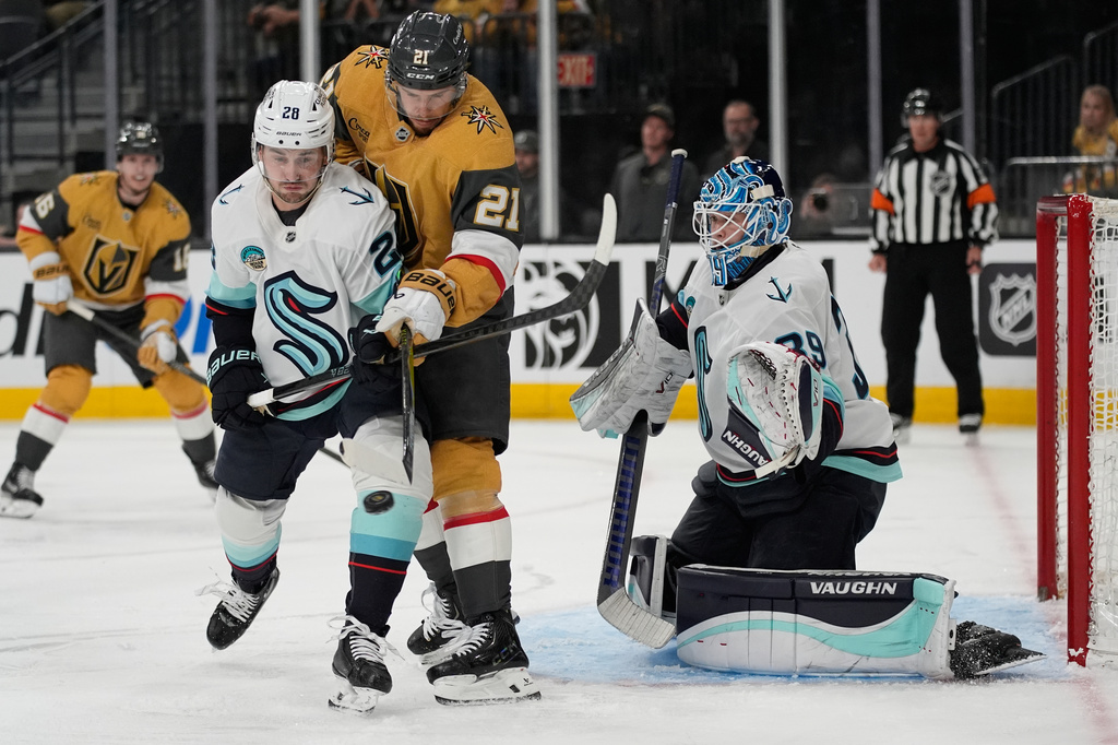Vegas Golden Knights center Brett Howden (21) attempts to tip is pasy Seattle Kraken goaltender Nikke Kokko (39) during the second period of an NHL hockey game Wednesday, April 15, 2026, in Las Vegas. (AP Photo/John Locher)