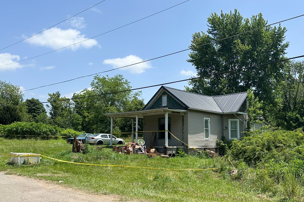 The dilapidated home where authorities say they removed 16 children and arrested four adults remains blocked off by crime scene tape on Wednesday, July 1, 2026 in Hamden, Ohio. (AP Photo/Julie Carr Smyth)