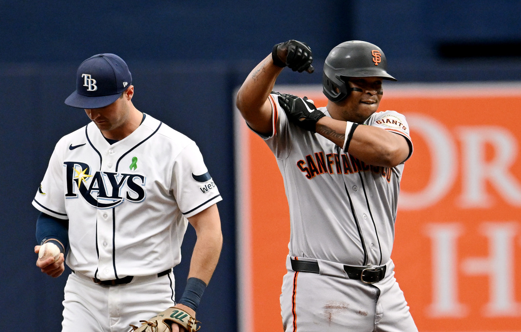 Tampa Bay Rays second baseman Ben Williamson, left, looks on as San Francisco Giants' Rafael Devers, right, celebrates after hitting a double during the first inning of a baseball game Sunday, May 3, 2026, in St. Petersburg, Fla. (AP Photo/Jason Behnken)