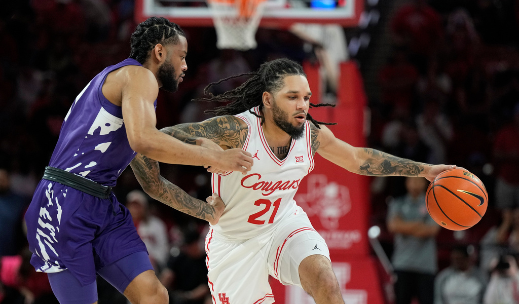 Houston guard Emanuel Sharp (21) controls the ball against Kansas State guard David Castillo, left, during the first half of an NCAA college basketball game, Saturday, Feb. 14, 2026, in Houston. (AP Photo/ Karen Warren)