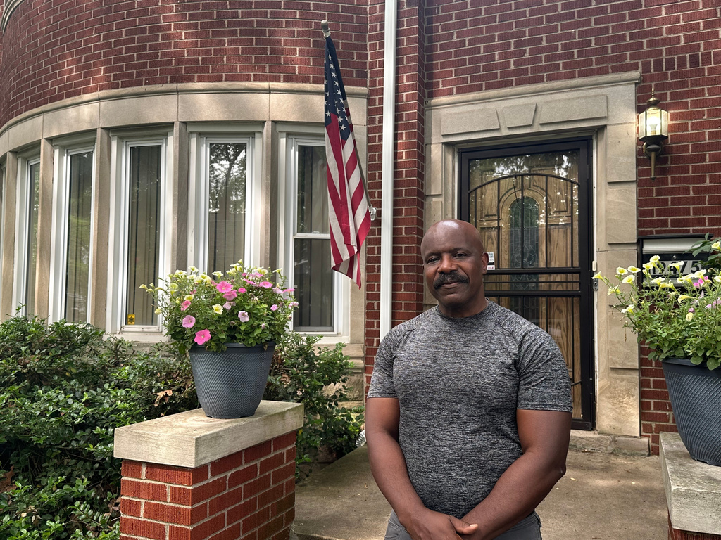 Jerry Esters stands in front of American flag outside his Detroit home on June 9, 2026. (AP Photo/Corey R. Williams)