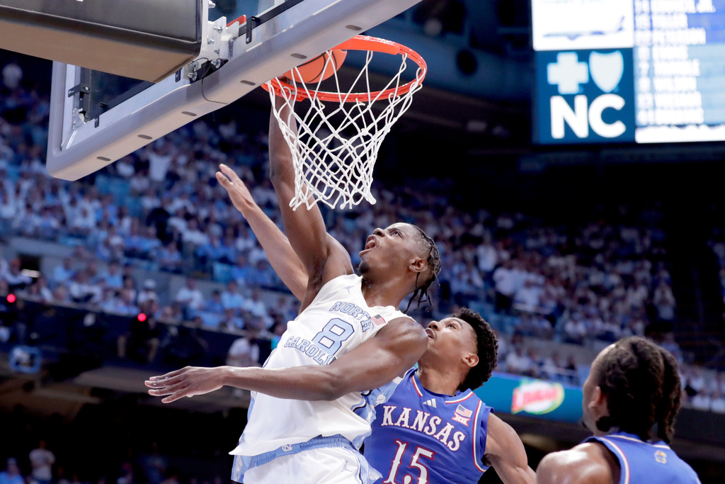 North Carolina forward Caleb Wilson (8) dunks over Kansas forward Bryson Tiller (15) during the first half of an NCAA college basketball game Friday, Nov. 7, 2025, in Chapel Hill, N.C. (AP Photo/Chris Seward)