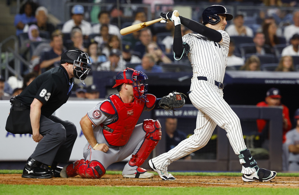 New York Yankees' Cody Bellinger, right, hits a single during the third inning of a baseball game against the Washington Nationals, Monday, Aug. 25, 2025, in New York. (AP Photo/Noah K. Murray)
