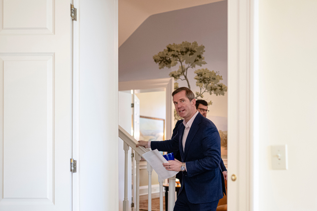 Kentucky Gov. Andy Beshear walks past his office before giving an interview, Monday, Jan. 12, 2026, in Frankfort, Ky. (AP Photo/Jon Cherry)