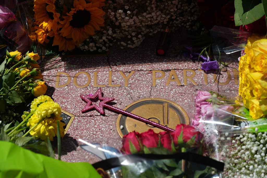 A wand with a star is placed over Dolly Parton's star on the Hollywood Walk of Fame Tuesday, Aug. 25, 2026, in Los Angeles. (AP Photo/Chris Pizzello)