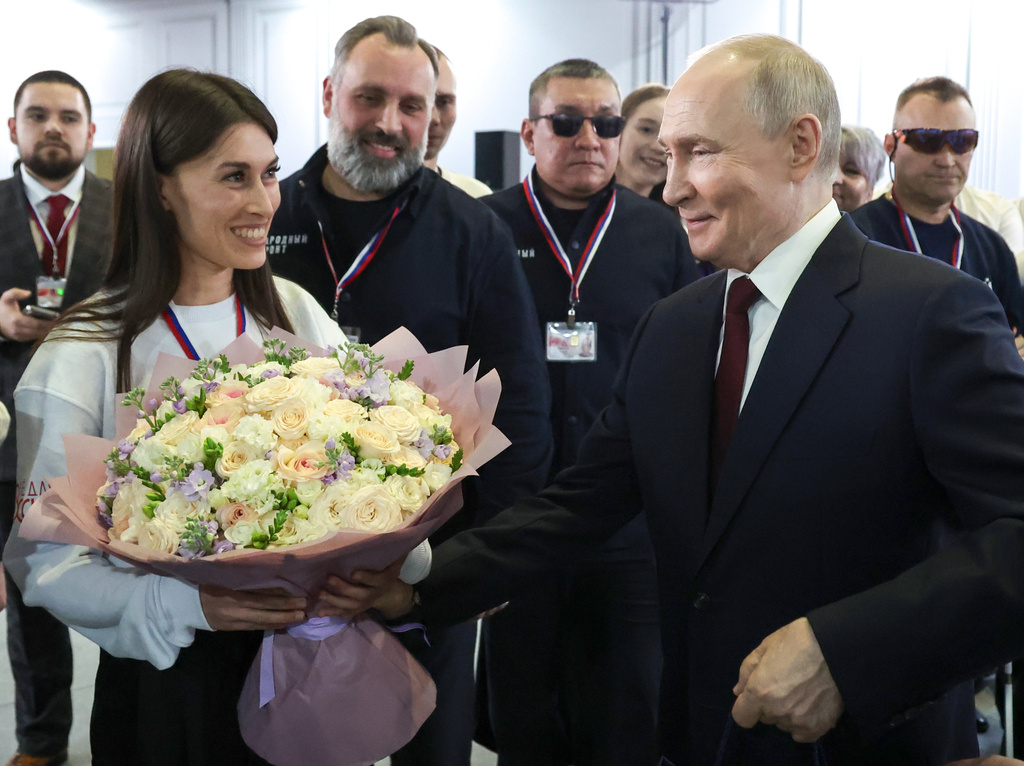 Russian President Vladimir Putin, right, thanks a group of volunteers who worked preparing his call-in show at Gostinny Dvor, in Moscow, on Friday, Dec. 19, 2025. (Alexander Kazakov, Sputnik, Kremlin Pool Photo via AP)