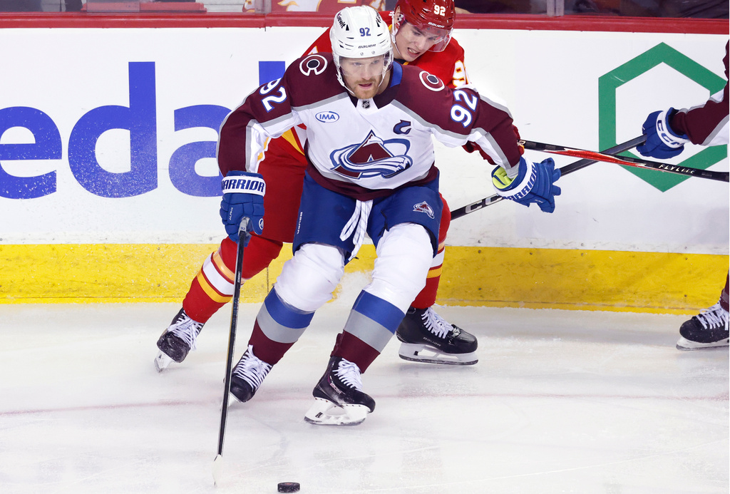 Colorado Avalanche's Gabriel Landeskog, front, battles for the puck against Calgary Flames' Matvei Gridin during the first period of an NHL hockey game, in Calgary, Alberta, Tuesday, April 14, 2026. (Larry MacDougal/The Canadian Press via AP)