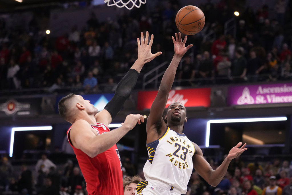Indiana Pacers guard Aaron Nesmith (23) shoots over Chicago Bulls center Nikola Vucevic (9) during the first half of an NBA basketball game in Indianapolis, Wednesday, Jan. 28, 2026. (AP Photo/Michael Conroy)