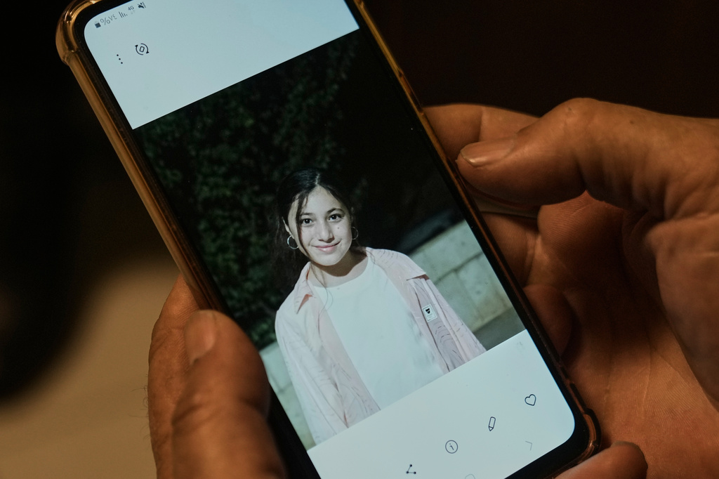 Hassan, the father of Zeinab al-Jabali, 10, who was killed on March 5, 2026, in an Israeli airstrike that hit her house in Libbaya village, east of Lebanon, shows a picture of his daughter, Zainab, during an interview at the office of doctor Ghassan Abu Sitta Fund, in Beirut, Lebanon, Thursday, March 19, 2026. (AP Photo/Bilal Hussein)