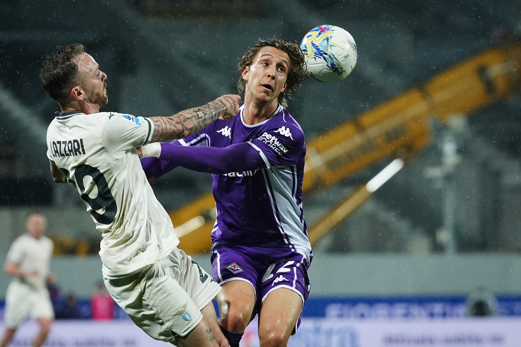 Lazio's Manuel Lazzari, left, fights for the ball with Fiorentina's Jacopo Fazzini during the Serie A soccer match between Fiorentina and Lazio in Florence, Italy, Monday, April 13, 2026. (Massimo Paolone/LaPresse via AP)