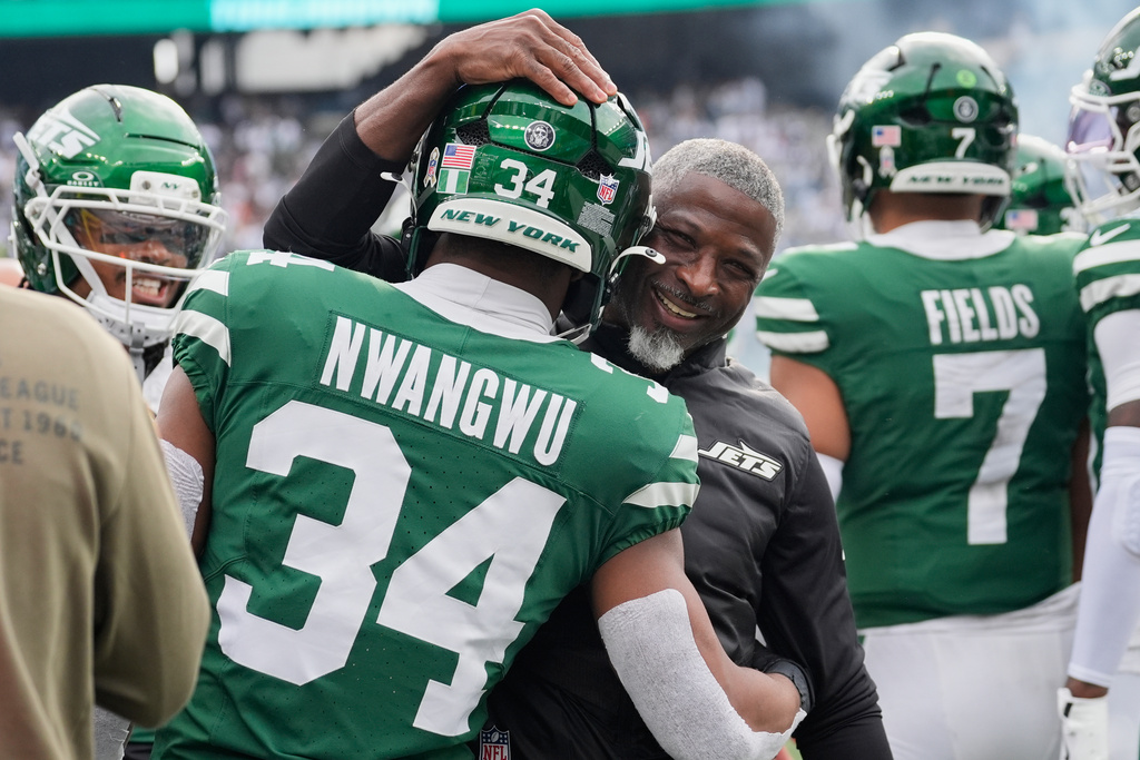 New York Jets head coach Aaron Glenn, center, celebrates with running back Kene Nwangwu (34) after Nwangwu's touchdown in the first of an NFL football game against the Cleveland Browns, Sunday, Nov. 9, 2025, in East Rutherford, N.J. (AP Photo/Yuki Iwamura)